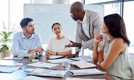 A group of four people in discussion in a conference room